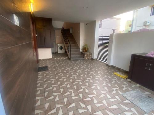 an empty room with a kitchen and a staircase at Kings Nest - Service Apartment Near VIT, Vellore in Vellore