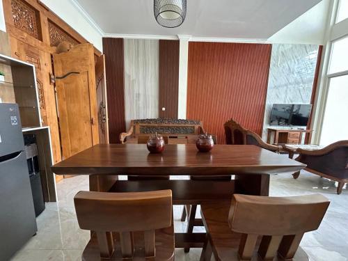 a dining room with a wooden table and chairs at Villa Lisha Orolas in Blimbing