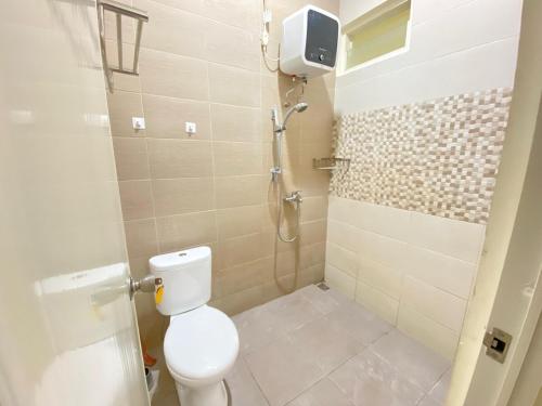 a bathroom with a toilet and a shower at Villa Lisha Orolas in Blimbing