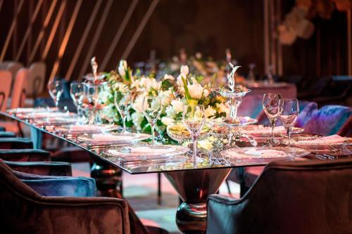 a long table with wine glasses and flowers on it at Sheraton Grand Doha Resort & Convention Hotel in Doha