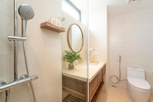a bathroom with a toilet and a mirror at Bonny Boutique Hotel Da Nang in Da Nang