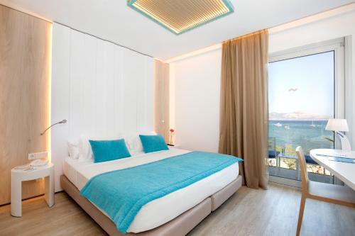 een slaapkamer met een groot bed en een groot raam bij La Goleta Hotel de Mar - Adults Only in Port de Pollença