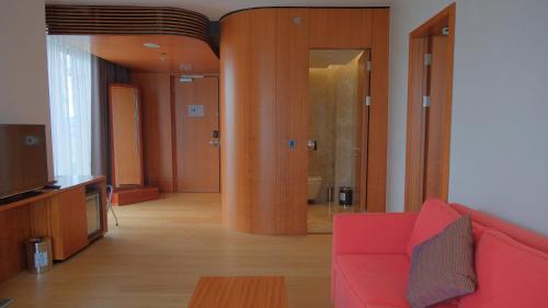 a living room with a red couch and a television at Crowne Plaza Kayseri by IHG in Kayseri