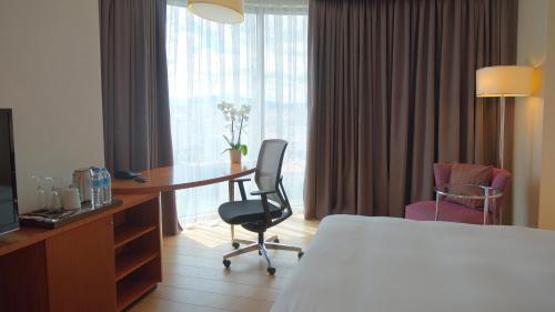 a hotel room with a bed and a desk and chair at Crowne Plaza Kayseri by IHG in Kayseri