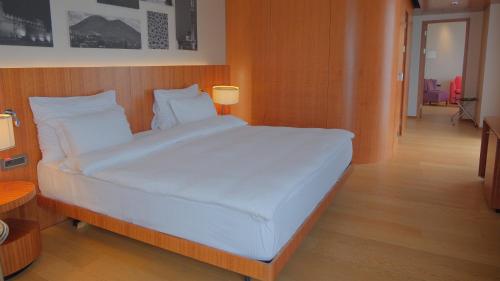a large white bed in a room with wooden floors at Crowne Plaza Kayseri by IHG in Kayseri