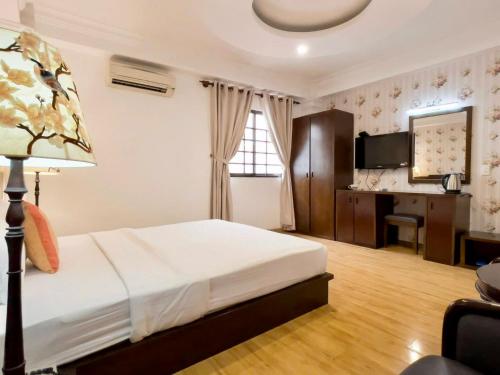 a bedroom with a bed and a desk in it at Little Brick Saigon Hotel in Ho Chi Minh City