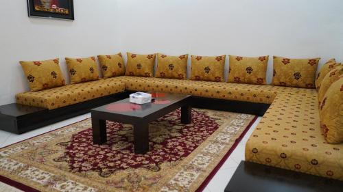 a living room with a couch and a coffee table at Hôtel Prestige in Nouadhibou