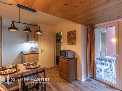 une petite cuisine avec une table et un micro-ondes dans l'établissement Appartement T3 avec terrasse, jardin et piscines à Cauterets - FR-1-401-310, à Cauterets