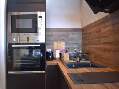 une cuisine avec un évier et un micro-ondes dans l'établissement Studio Charmant à Font-Romeu avec Vue Pyrénées - FR-1-580-128, à Font-Romeu-Odeillo-Via