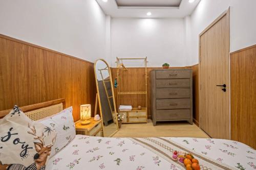 a bedroom with a bed and a dresser at Nguyên căn 4 giường YA Beach Da Nang in Da Nang
