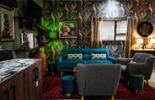 a living room with a blue couch and chairs at Rarebird Waverley in Bloemfontein