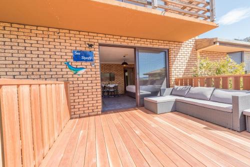 a patio with a couch on a wooden deck at Sea Shanty in Bicheno