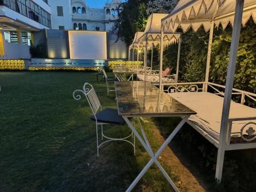 a table and chairs in a yard with a tent at Elephant Pushkar in Pushkar