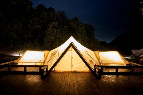 a tent with two chairs on a deck at night at 五浦 幽谷隠田跡温泉 Hidden Traces of Rice Terraces Hot Spring - Izura in Kitaibaraki