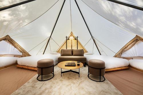 a room with two beds and a table in a tent at 五浦 幽谷隠田跡温泉 Hidden Traces of Rice Terraces Hot Spring - Izura in Kitaibaraki