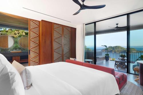 a bedroom with a white bed and a balcony at Nekajui, a Ritz-Carlton Reserve in Papagayo, Guanacaste