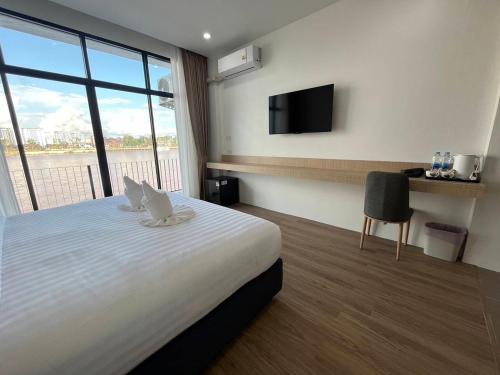 金三角View khong Hotel โรงแรมวิวโขง的酒店客房设有一张床铺,墙上配有电视。