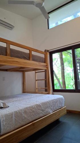 a bedroom with two bunk beds and a window at Green Turtle Townhome #1 Private Pool & Garden 300 Mtrs to Beach in Tamarindo