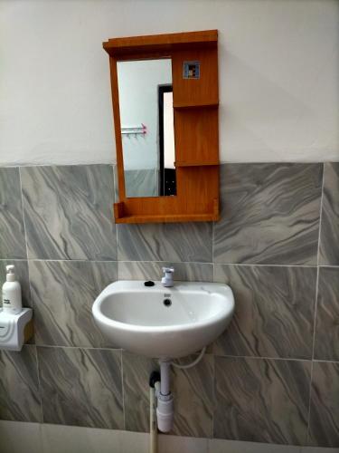 a bathroom with a sink and a mirror at Tania Homestay in Bumbang