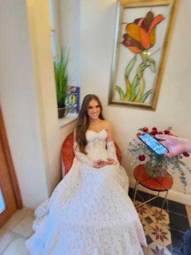 a woman in a wedding dress sitting in a room at כוהנ'ס Cohen's Boutique Hotel in Haifa