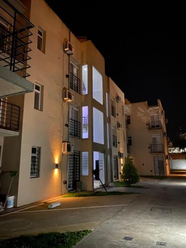 an empty street in front of a building at night at Enjoy Apart Campana in Campana