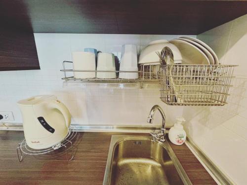 a kitchen with a sink and a shelf with dishes at Seaview 3rd floor วิวทะเล 1Bedroom 1Bathroom 33Sqm in Jomtien Beach