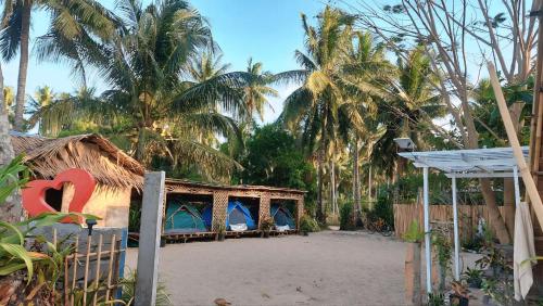 un resort con tende su una spiaggia con palme di AKOYA Beachfront Tent house a El Nido