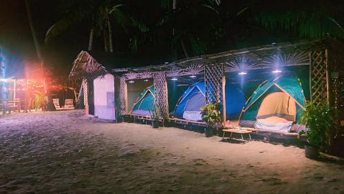 un gruppo di tende sulla spiaggia di notte di AKOYA Beachfront Tent house a El Nido