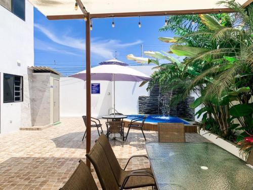 a patio with a table and chairs and an umbrella at Departamento exclusivo en salinas in Salinas
