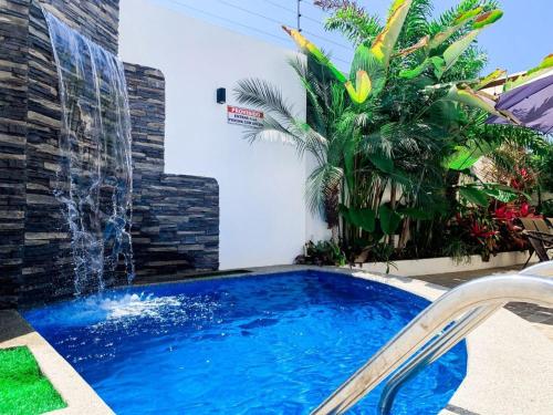 a swimming pool with a waterfall in a backyard at Departamento exclusivo en salinas in Salinas