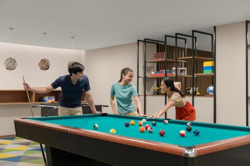a group of people standing around a pool table at Sheraton Cebu Mactan Resort in Mactan
