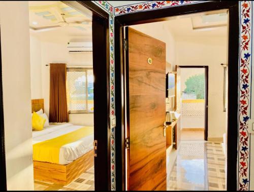 a door leading to a bedroom with a bed and a bed sqor at Vallabhgarh A lake facing balcony in Udaipur