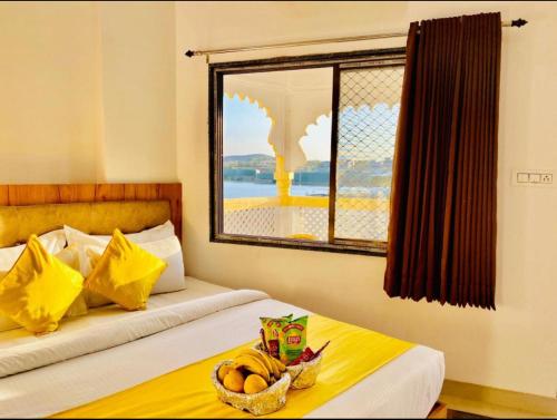 a bedroom with two beds with a window and a basket of fruit at Vallabhgarh A lake facing balcony in Udaipur