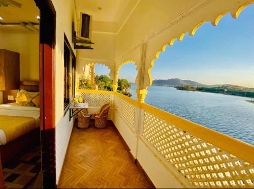 a balcony of a hotel with a view of the water at Vallabhgarh A lake facing balcony in Udaipur