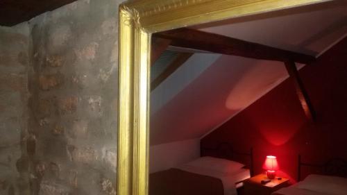 a mirror in a room with a bed and a lamp at Bed and Breakfast "Caffe-caffe" in Kikinda