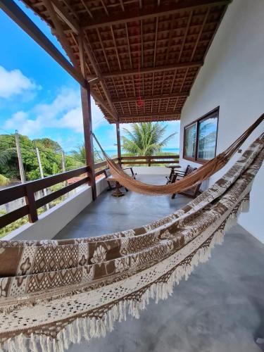 a hammock in a room with a view of the ocean at Casa Amor With Sea View in Goiana
