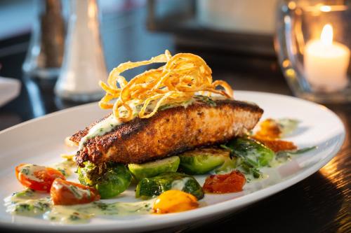 a plate of food with a piece of fish and vegetables at Le Meridien Dallas by the Galleria in Dallas