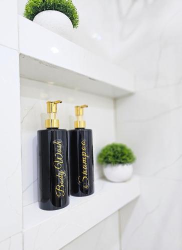 two black bottles of essential oils sitting on a shelf at Nalahost 2BR oceanview Apartment in Male City