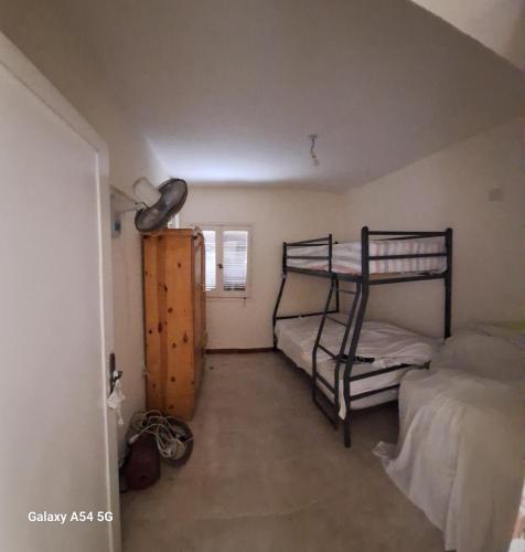 a bedroom with two bunk beds and a window at سكن سيدى عبدالرحمن in Sīdī ‘Abd ar Raḩmān