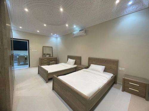 Un dormitorio con dos camas y un techo. en Alzahra residence 4 km to AlHaram, en La Meca