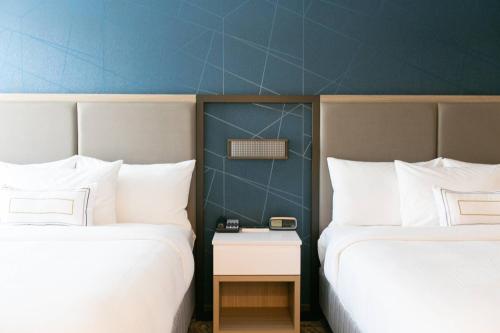 two beds in a hotel room with a table between them at SpringHill Suites by Marriott South Bend Notre Dame Area in South Bend
