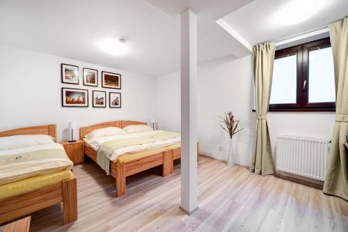 a bedroom with two beds and a window at Penzion Královská Cesta in Brno