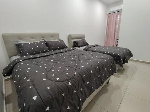 1 dormitorio con 2 camas con edredón y almohadas negros en dotMy Homestay Kluang 15 pax - NETFLIX - WiFi - Autogate - 4 Rooms - 4 Bathrooms, en Keluang