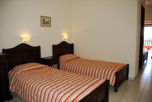 two beds sitting next to each other in a room at Pansion Nikos in Patitiri