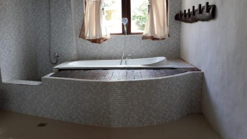 a bath tub in a bathroom with a window at Rara Villas Lombok in Senggigi 