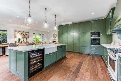 a kitchen with green cabinets and white counter tops at Villa Northcote Luxurious 4BR Wood Fireplace Leura in Leura