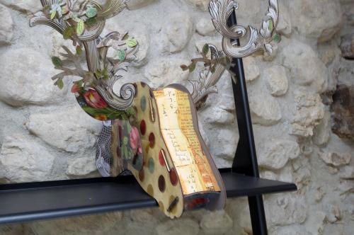 a sign hanging from a wall with a vase at Le Petit Chalande in Autrans