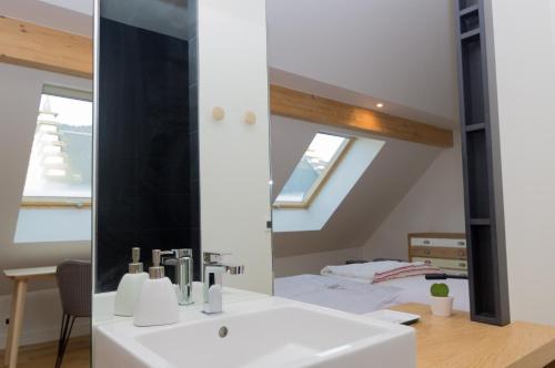 a bathroom with a white sink and a mirror at Le Petit Chalande in Autrans