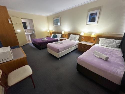 Una cama o camas en una habitación de The Q Motel Rockhampton