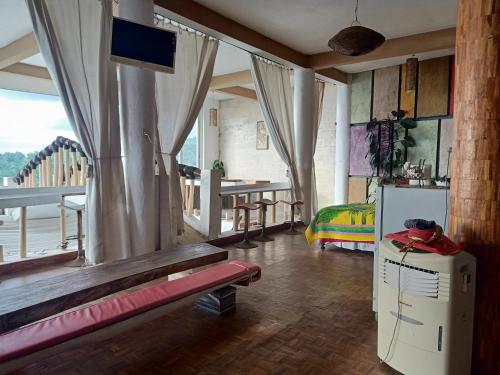 a room with a bed and a television and a table at Rara Villas Lombok in Senggigi 